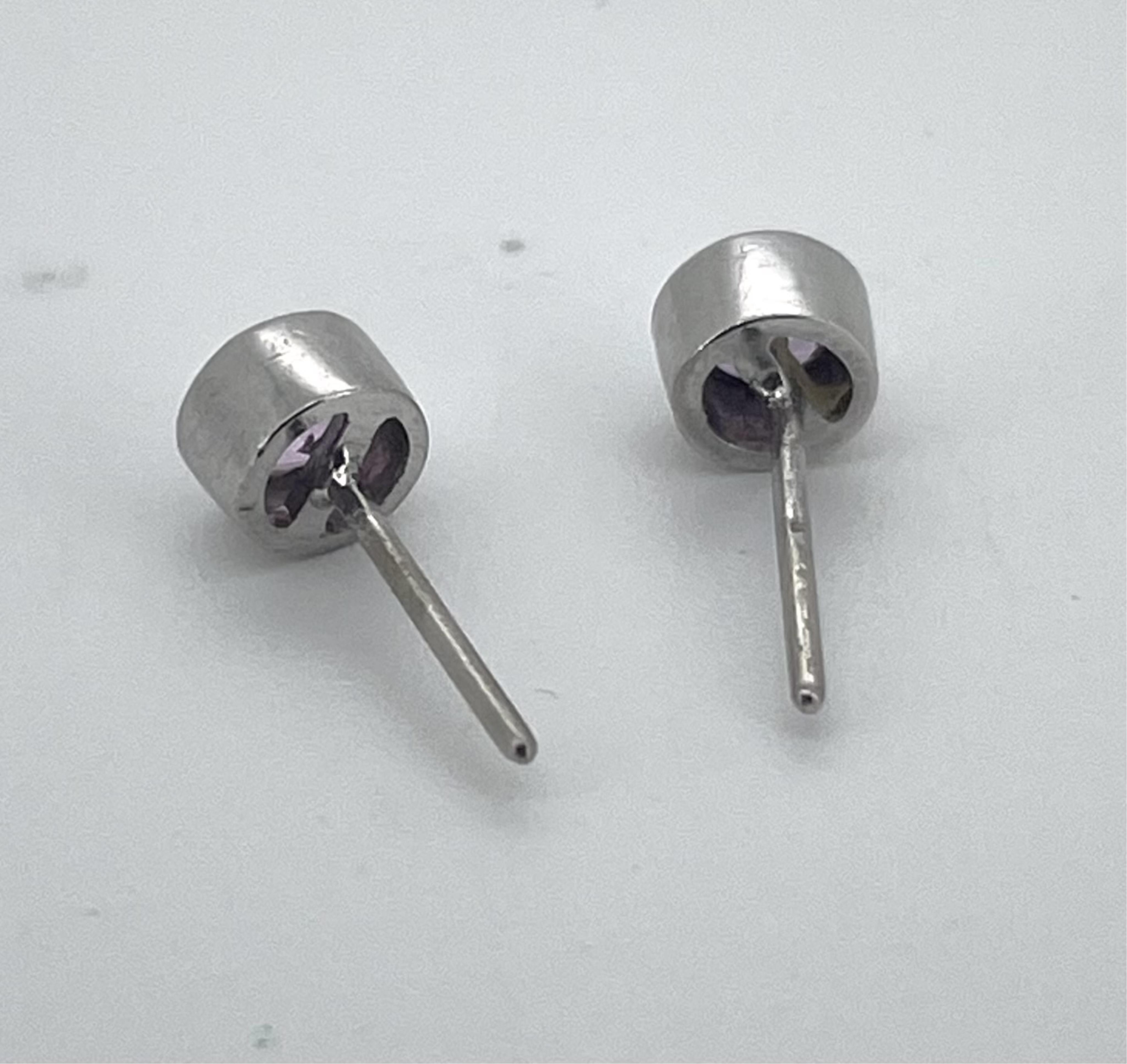 A pair of modern white metal, stamped 750 and single stone pink sapphire set ear studs, gross weight 1.5 grams.